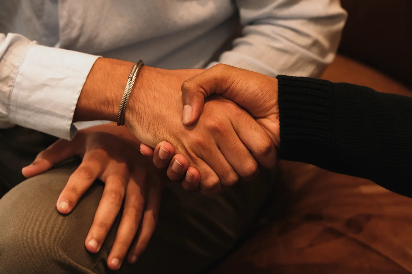 Two Tiempo team members shaking hands on a couch