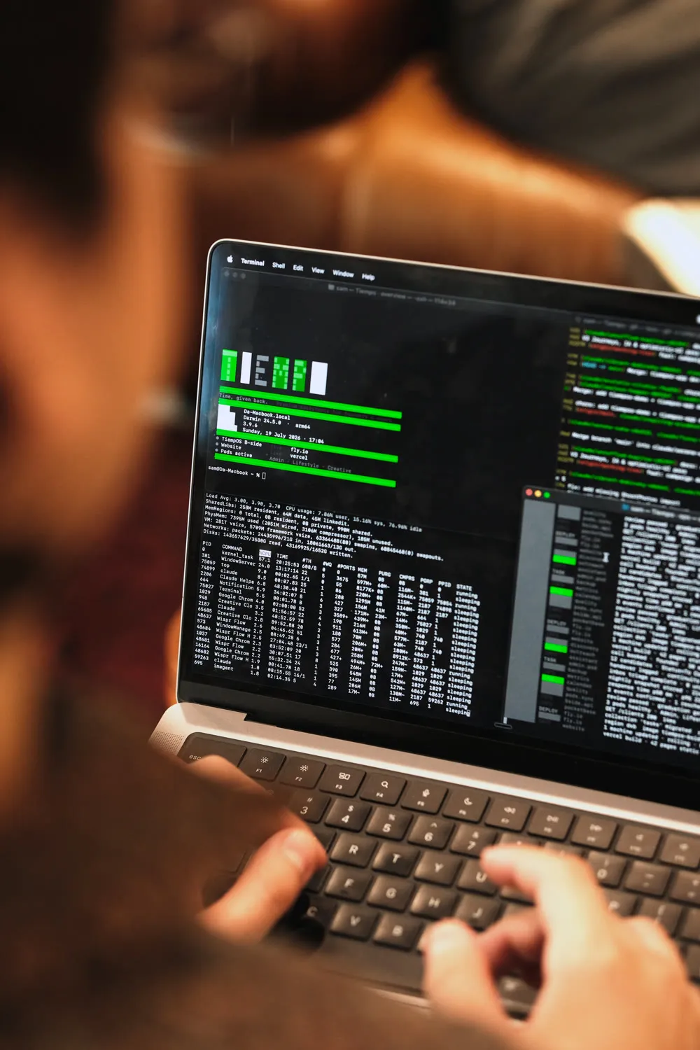 A Tiempo team member typing at a laptop running the Tiempo terminal dashboard