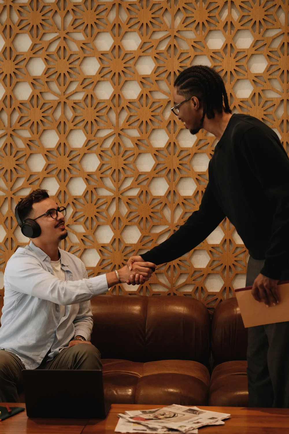 Two Tiempo team members shaking hands, one seated and one standing