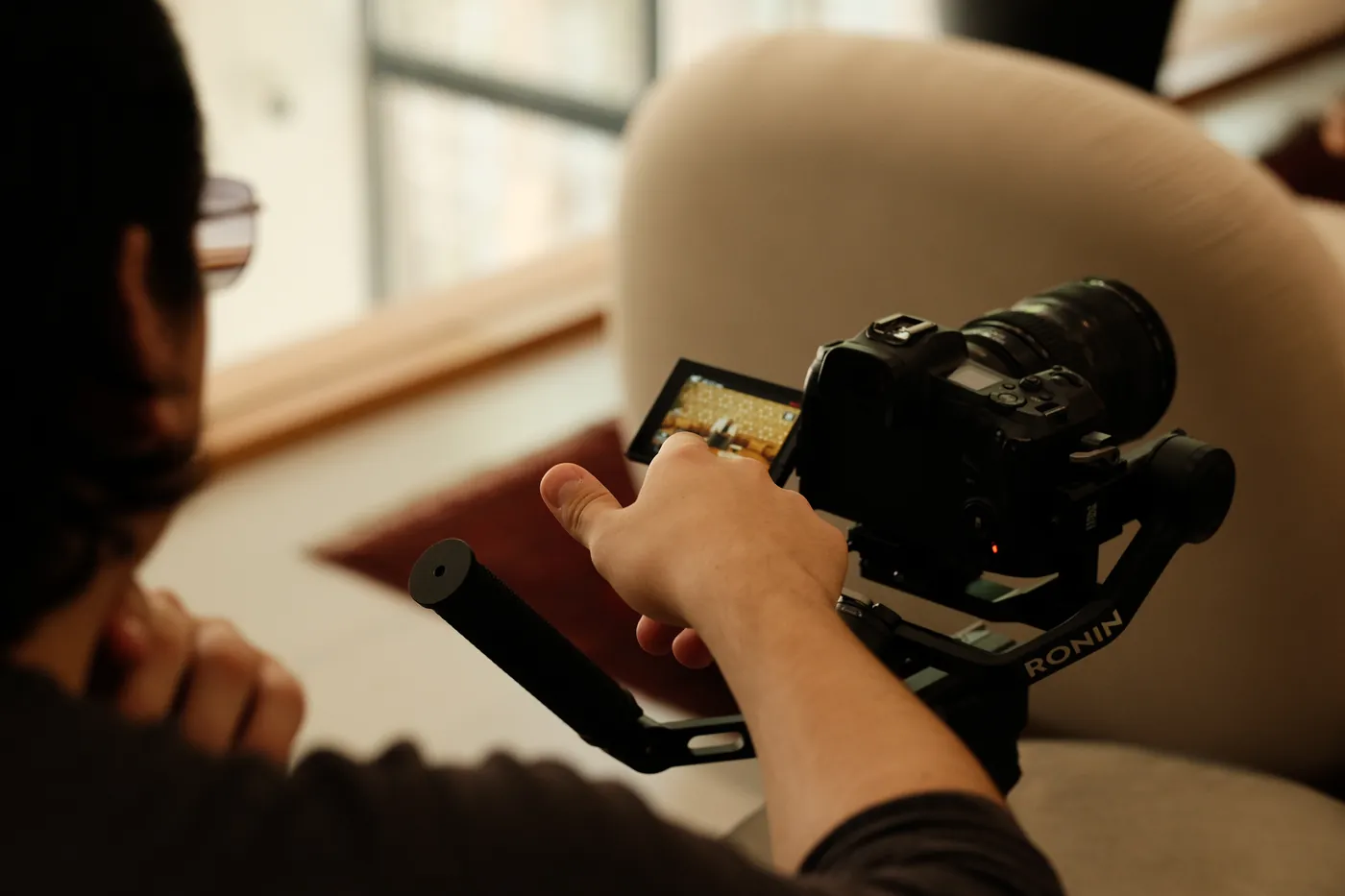 A videographer framing a shot on a gimbal-mounted camera